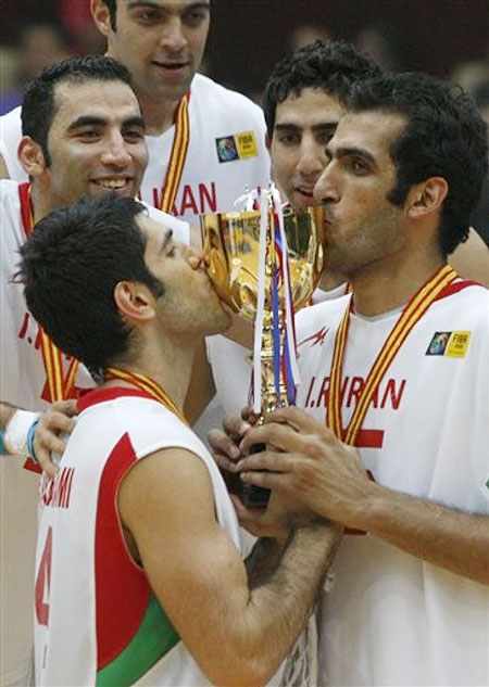 Iran's Hamed Hadadi, right and Mohammadsamad Nikkhah Bahrami, left kiss the trophy after winning the finals of the 25th FIBA Asia Basketball Championship held in Tianjin, China, Sunday, Aug 16, 2009. Iran defeated China 70-52.